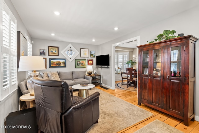 living room with baseboards, light wood-type flooring, and recessed lighting