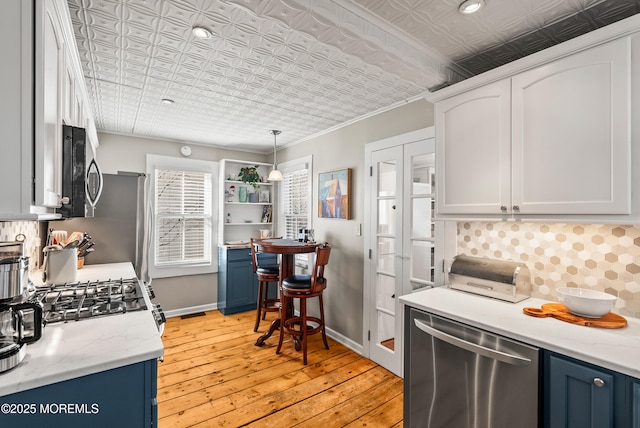 kitchen with stainless steel appliances, backsplash, an ornate ceiling, and blue cabinets