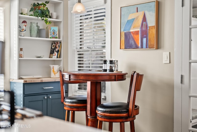 bar featuring built in features and hanging light fixtures