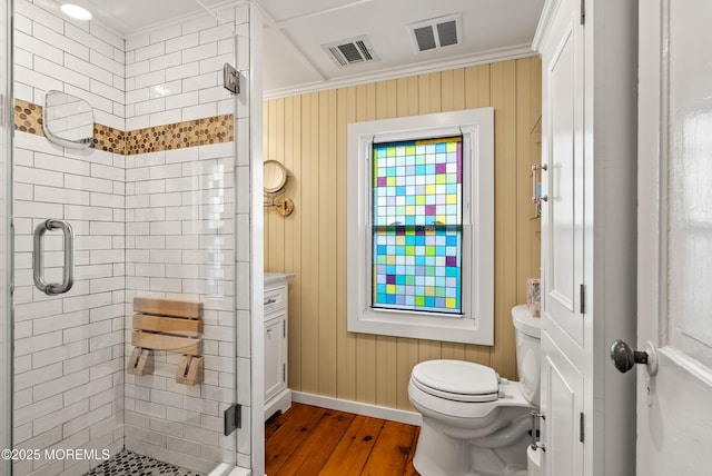 bathroom featuring toilet, a stall shower, and visible vents