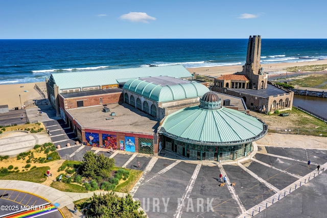 bird's eye view with a water view and a beach view