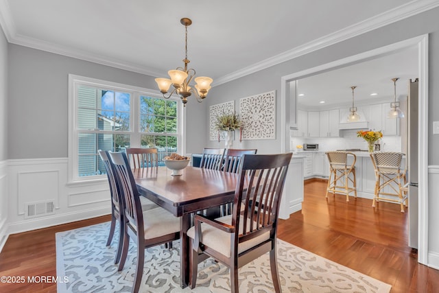 dining space with a chandelier, light hardwood / wood-style floors, and crown molding