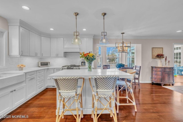 kitchen featuring a kitchen breakfast bar, pendant lighting, and white cabinetry