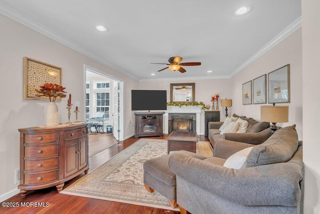 living room featuring hardwood / wood-style flooring, ceiling fan, and crown molding