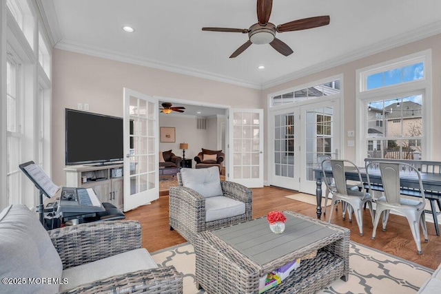 living room featuring french doors, crown molding, and light hardwood / wood-style flooring