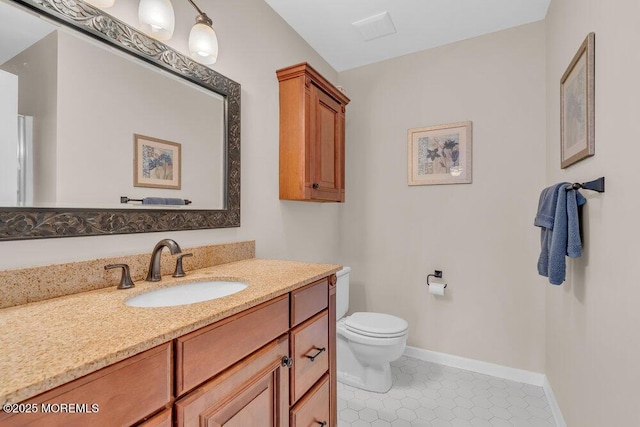 bathroom with toilet, tile patterned floors, and vanity