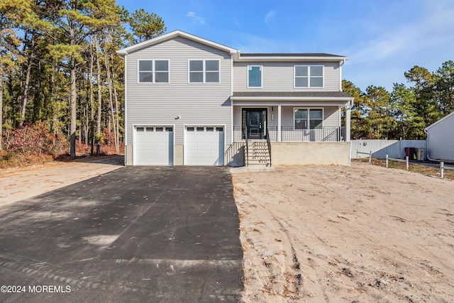 view of property with a porch and a garage