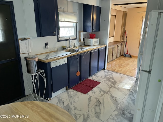 kitchen with blue cabinets, freestanding refrigerator, marble finish floor, and dishwasher