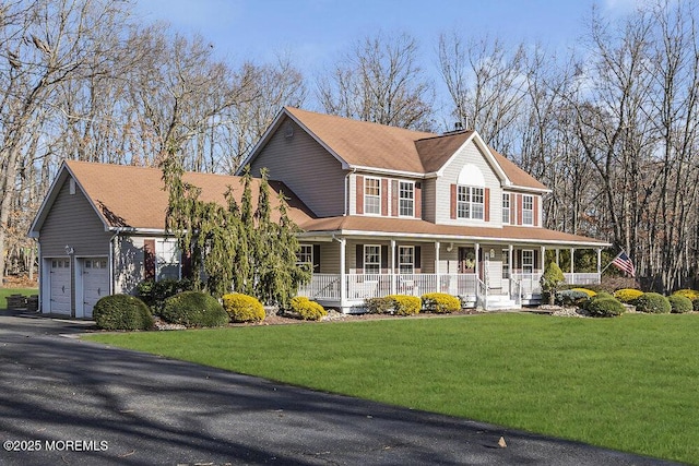 view of front of house featuring a porch, a garage, and a front lawn