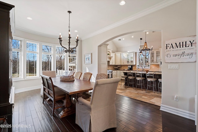 dining room featuring dark wood-type flooring, crown molding, and a notable chandelier