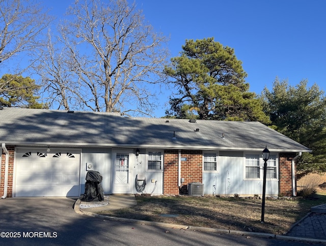 ranch-style house featuring cooling unit and a garage