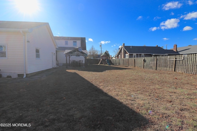 view of yard with a gazebo, fence, and a playground