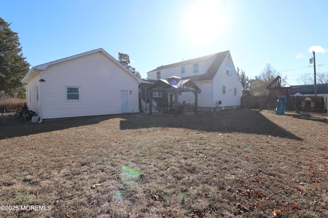 rear view of property with a yard and fence