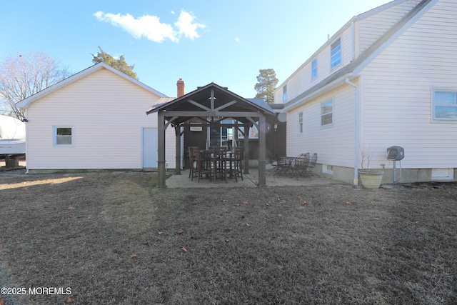 back of property with a patio area, a lawn, and a gazebo