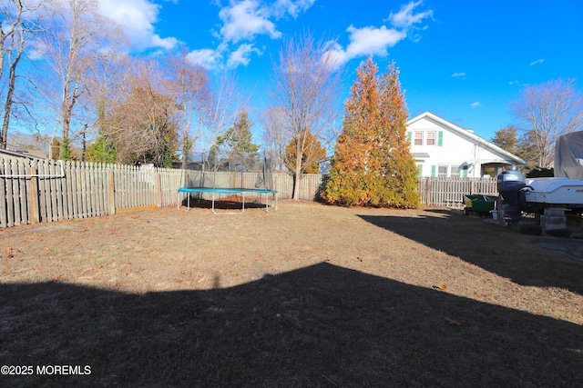 view of yard with a trampoline and a fenced backyard