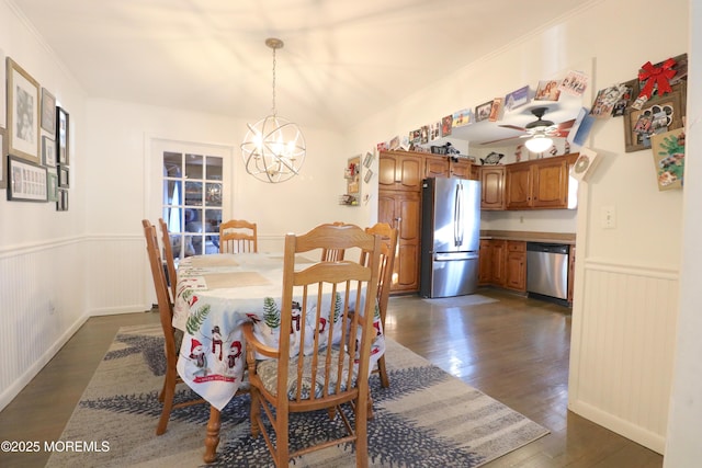 dining area with an inviting chandelier, dark wood-style floors, a wainscoted wall, and a wealth of natural light