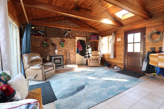 living room featuring wooden walls, a wood stove, vaulted ceiling with beams, wood ceiling, and tile patterned floors