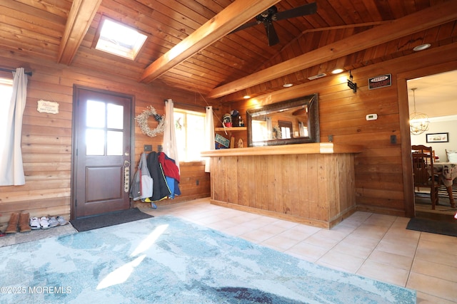 kitchen with wooden walls, vaulted ceiling with beams, and wood ceiling