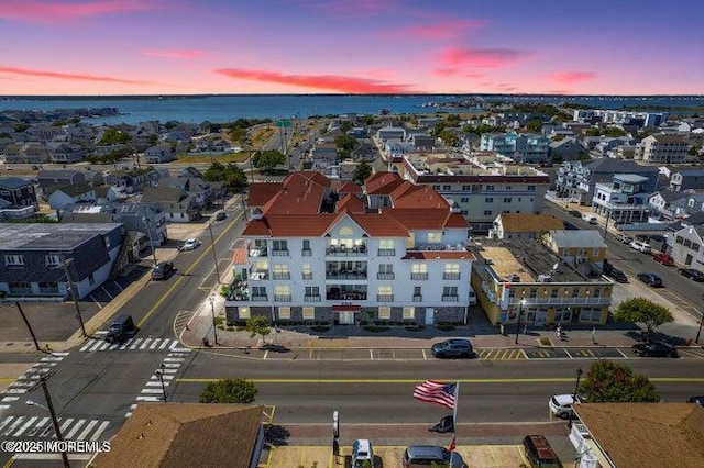 aerial view at dusk featuring a water view