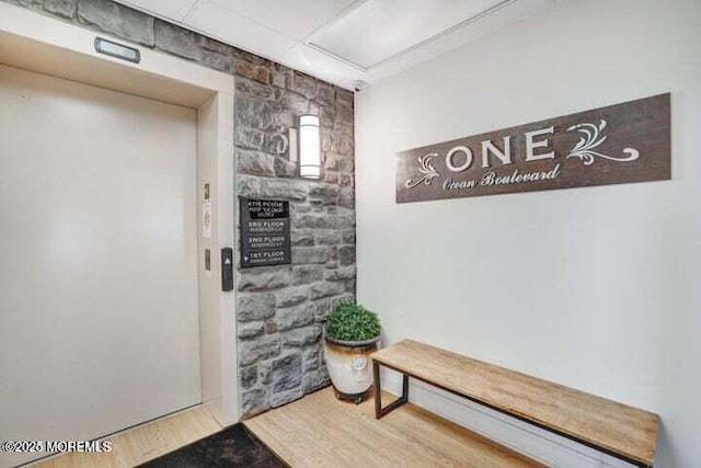 hallway with elevator and hardwood / wood-style floors