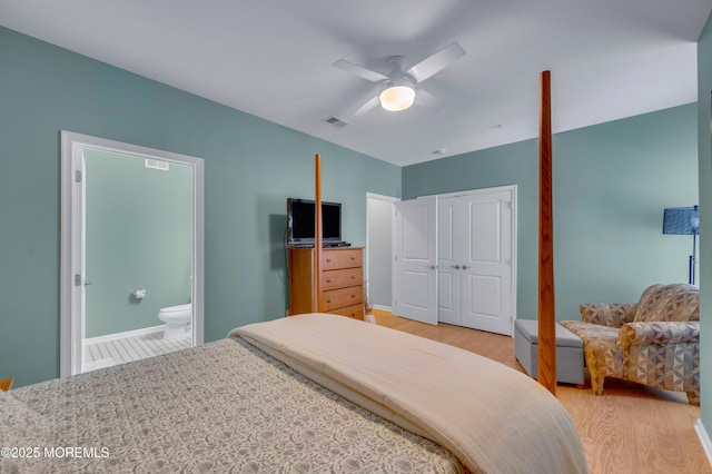 bedroom featuring ensuite bath, a closet, light hardwood / wood-style flooring, and ceiling fan