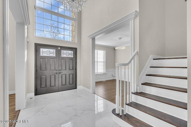 foyer entrance with a high ceiling and a notable chandelier