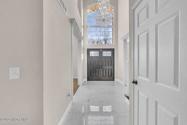 entrance foyer with a notable chandelier and a towering ceiling