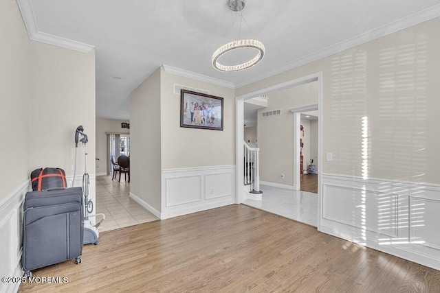 corridor with ornamental molding and light hardwood / wood-style flooring