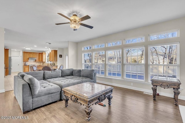 living room with ceiling fan, a healthy amount of sunlight, and light hardwood / wood-style floors