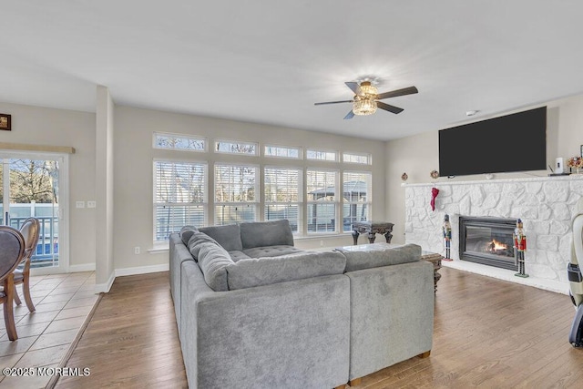 living room with hardwood / wood-style flooring, ceiling fan, and a fireplace