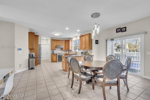 tiled dining area featuring sink and plenty of natural light