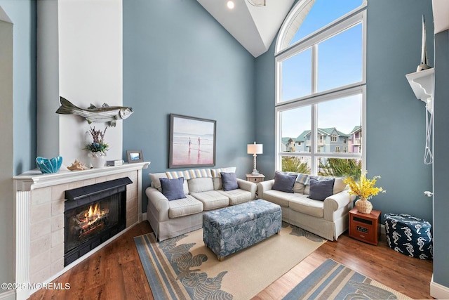 living room featuring a tiled fireplace, hardwood / wood-style floors, and a healthy amount of sunlight