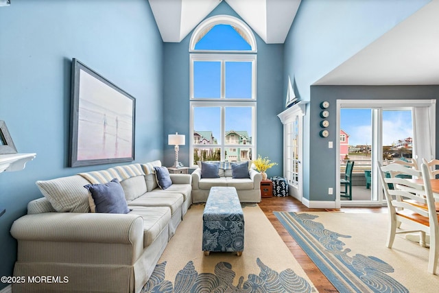 living room with hardwood / wood-style floors and high vaulted ceiling