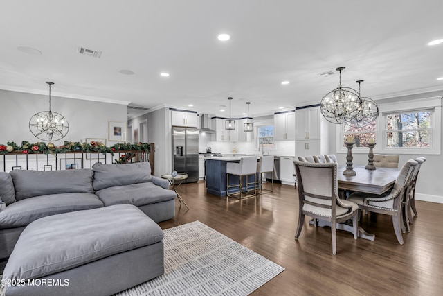 living room featuring visible vents, a notable chandelier, ornamental molding, recessed lighting, and dark wood-style flooring