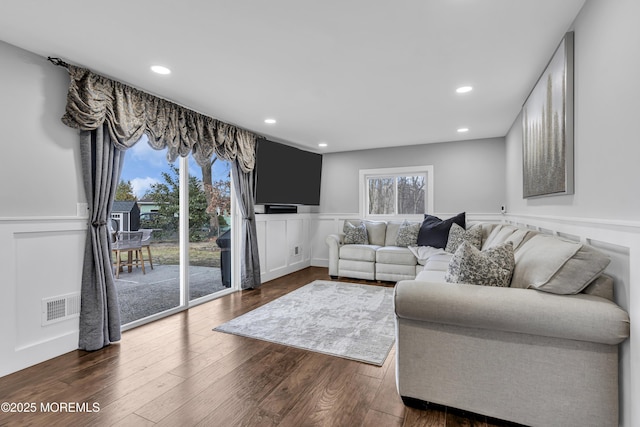 living room featuring visible vents, a wainscoted wall, recessed lighting, dark wood-style floors, and a decorative wall