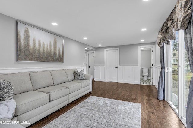 living area with recessed lighting, a wainscoted wall, and wood finished floors