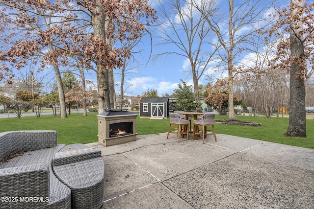 view of patio / terrace with a storage shed, a warm lit fireplace, and an outdoor structure