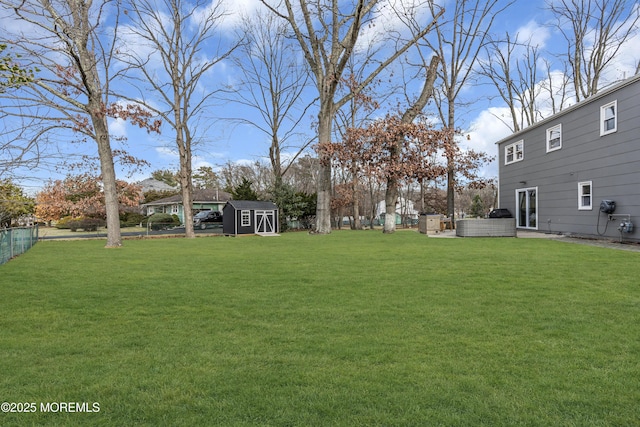 view of yard featuring a storage unit, an outbuilding, and fence