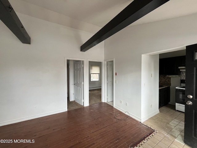 unfurnished room featuring baseboard heating, light hardwood / wood-style flooring, and beamed ceiling