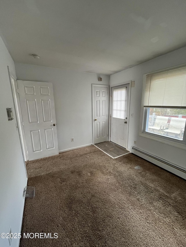 entryway with baseboards, baseboard heating, and carpet flooring