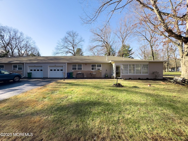 ranch-style home with a garage and a front lawn