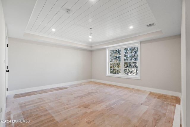 unfurnished room featuring a tray ceiling, wooden ceiling, and light wood-type flooring