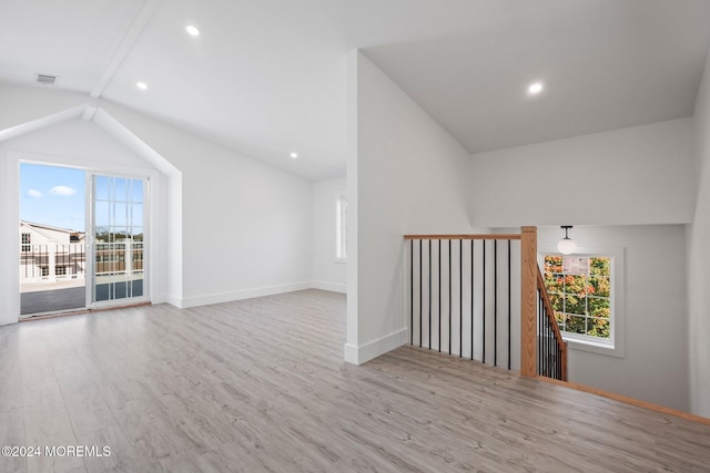 interior space featuring light wood-type flooring and vaulted ceiling