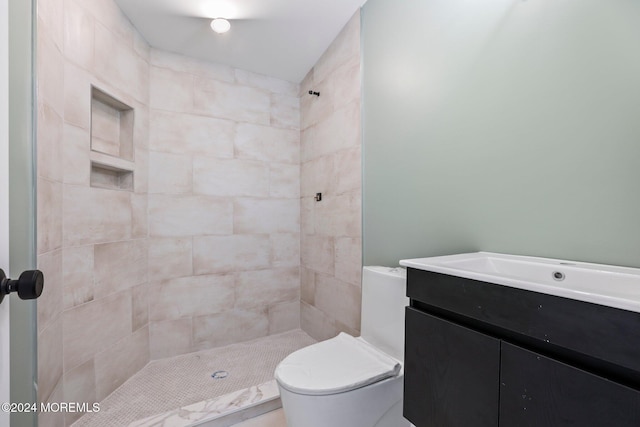 bathroom featuring vanity, toilet, and tiled shower