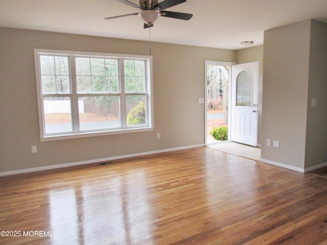 unfurnished room featuring ceiling fan, light wood-type flooring, and a wealth of natural light