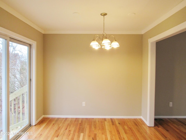 empty room with wood-type flooring, ornamental molding, and a notable chandelier