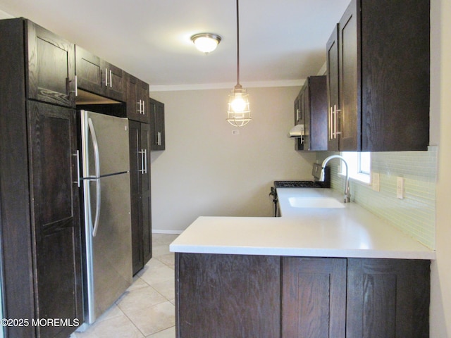 kitchen with pendant lighting, sink, decorative backsplash, light tile patterned floors, and kitchen peninsula