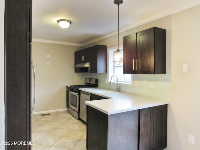 kitchen featuring tasteful backsplash, dark brown cabinetry, sink, stainless steel range oven, and hanging light fixtures