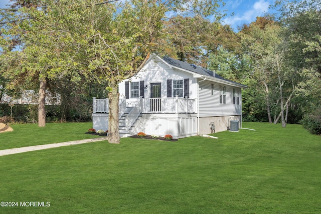 view of front of home featuring a deck, a front lawn, and cooling unit