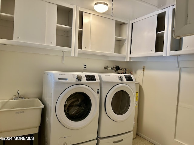 laundry room with cabinets, sink, and washing machine and dryer